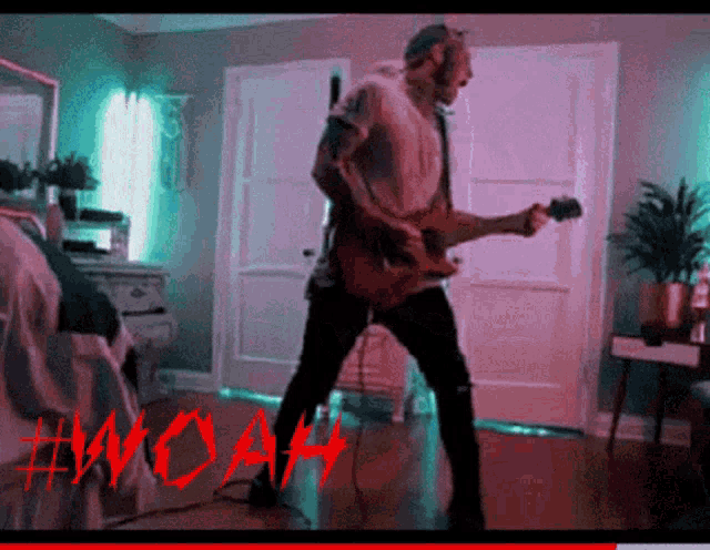 a man is playing a guitar in a room with the word woah on the bottom