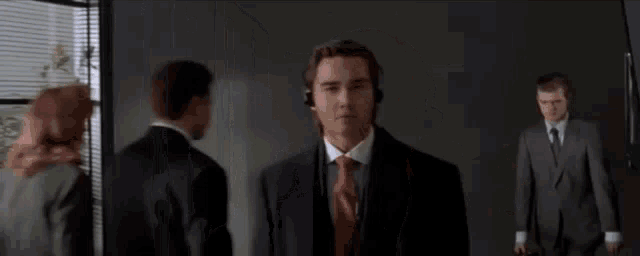 a man in a suit and tie is wearing headphones while walking