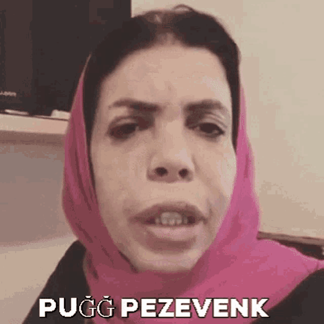 a woman wearing a pink head scarf is making a funny face and says pug pezevenk