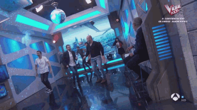 a group of people dancing in a room with a sign that says the voice