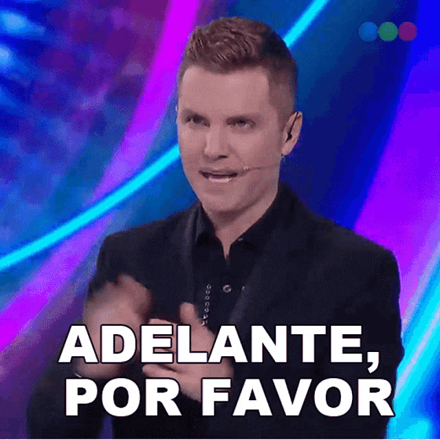 a man with a microphone says adelante por favor in spanish