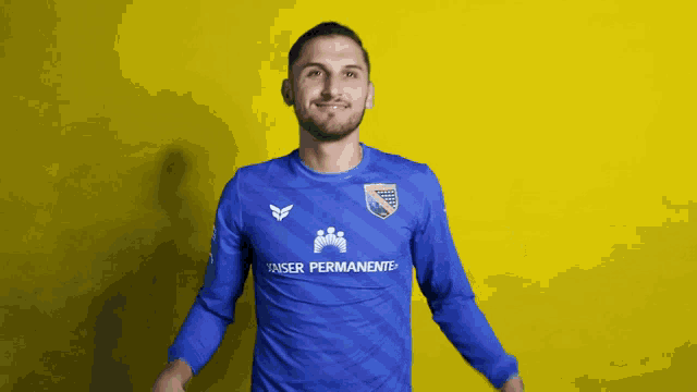 a man wearing a blue shirt that says tanser permanente