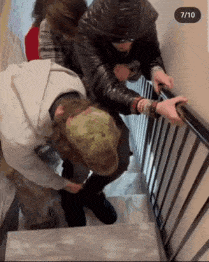a group of people are walking down stairs with a 7/10 sticker on the bottom