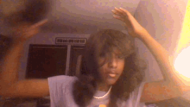a woman wearing a pearl necklace and a wig is dancing