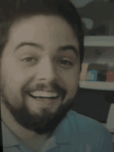 a man with a beard is smiling with his eyes closed and his mouth open