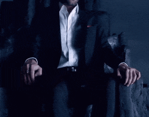 a man in a suit is sitting on a throne