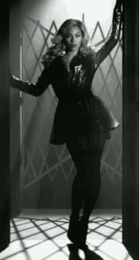 a black and white photo of a woman in a black dress