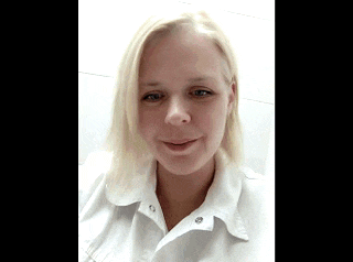 a woman in a white shirt is smiling and looking at the camera