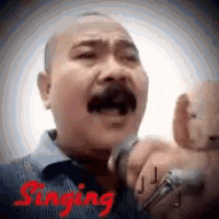 a man with a mustache is singing into a microphone with the word singing in red .