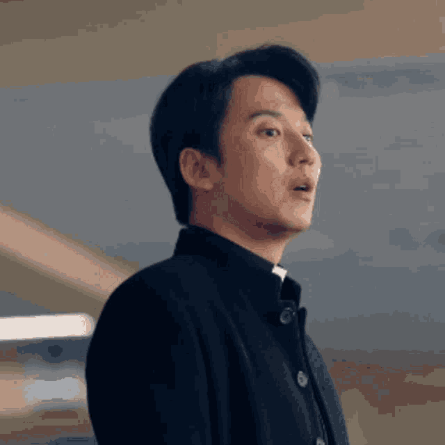 a man with a surprised look on his face wearing a black jacket