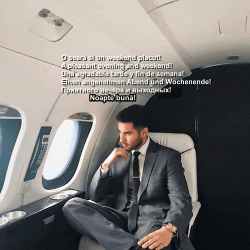 a man in a suit and tie is sitting on a plane with a greeting in another language