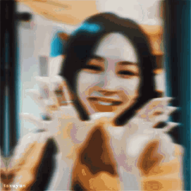 a blurry picture of a woman smiling and holding a cat