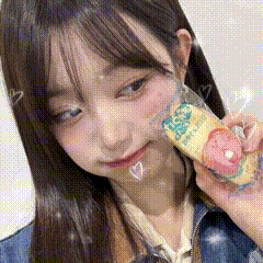 a close up of a girl holding a candy bar in her hand .