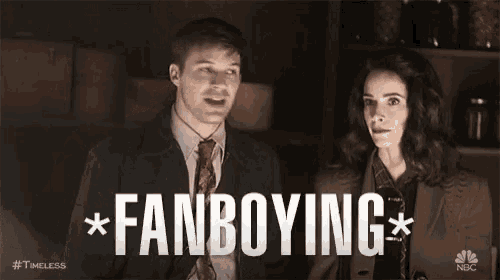 a man and a woman are standing next to each other and the man is pointing at the woman and saying fanboying .