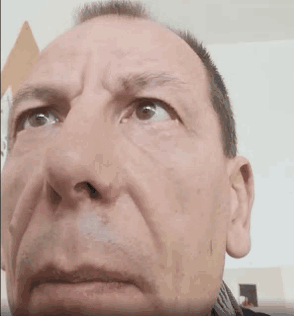 a close up of a man 's face with a scarf around his neck looking at the camera .
