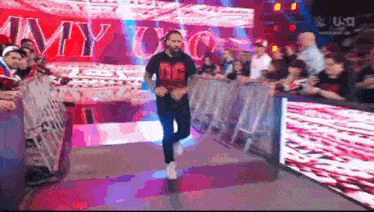 a man wearing a shirt that says dg is running through a crowd