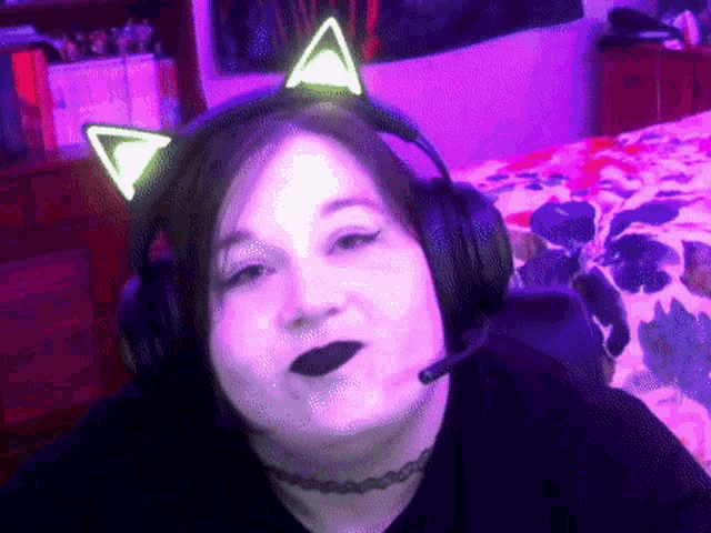 a woman wearing headphones and a choker looks at the camera