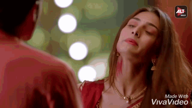 a woman in a red dress is looking at a man in a red shirt in a video that was made with vivavideo