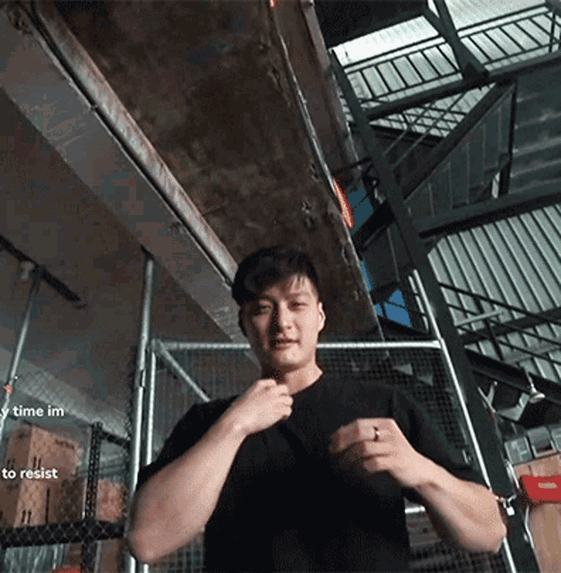 a man with a ring on his finger stands in front of a staircase with the words " time im to resist " on the bottom