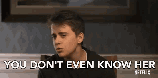 a young man is sitting at a table and saying `` you don 't even know her netflix '' .