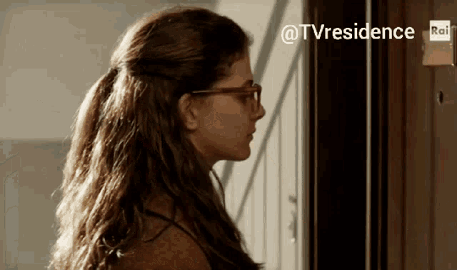 a woman wearing glasses is standing in front of a door with the hashtag @tvresidence