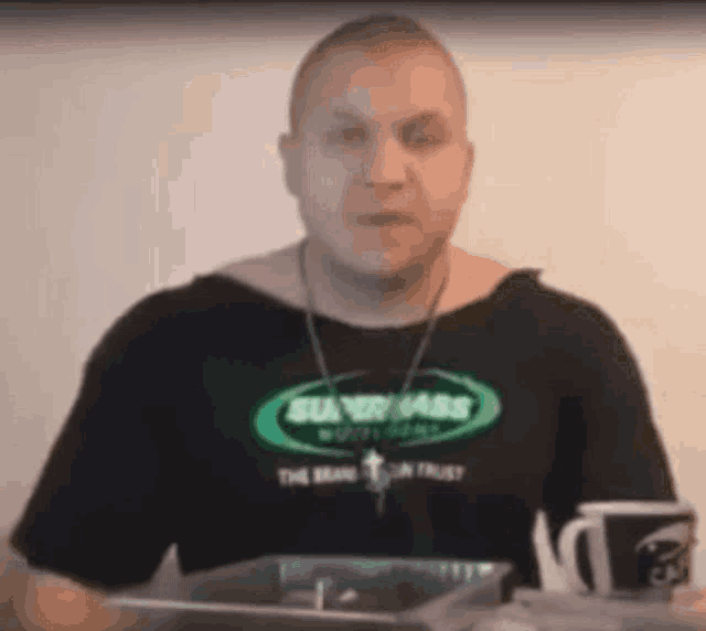 a man wearing a black shirt that says super mass