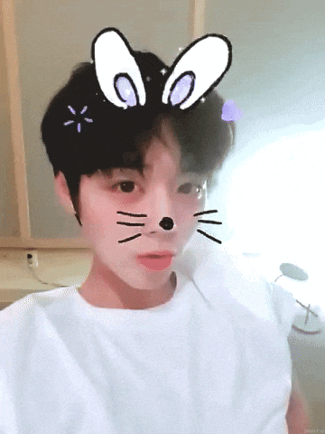 a young boy wearing a white t-shirt with a cat face on his face