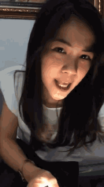 a woman is smiling and looking at the camera