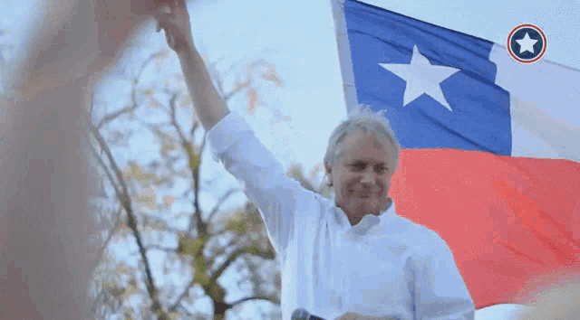 a man in a white shirt is holding a flag with a white star on it