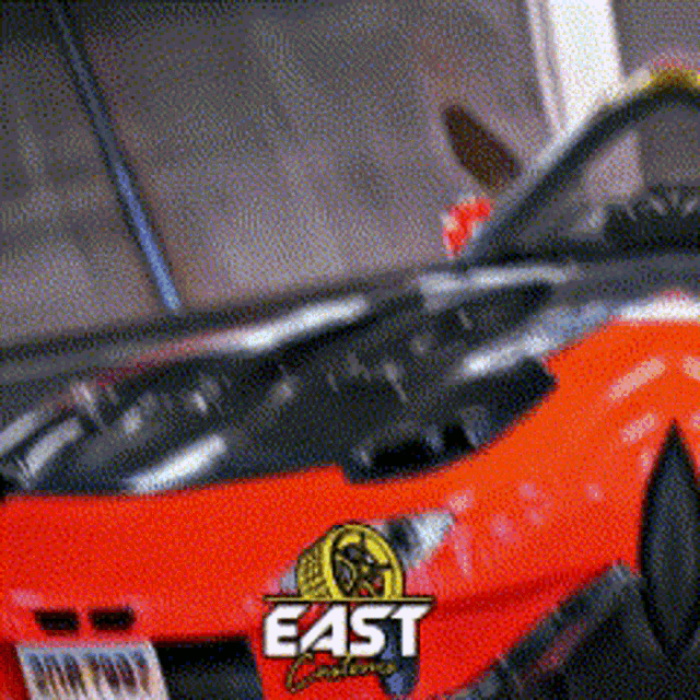 a close up of an orange car with the word east on the front