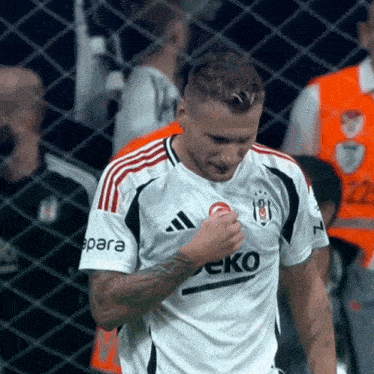 a soccer player wearing a white jersey with the word eko on it