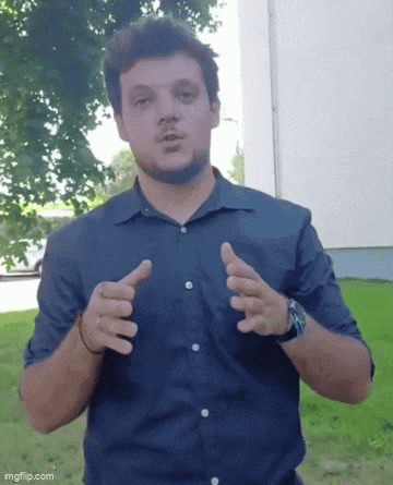 a man in a blue shirt is giving a thumbs up gesture
