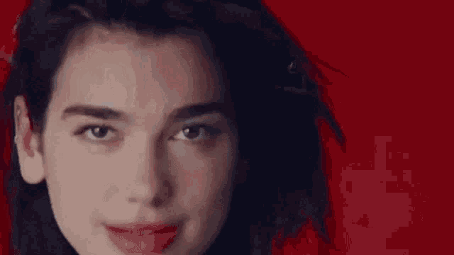 a close up of a woman 's face with her eyes closed and a smile on her face .