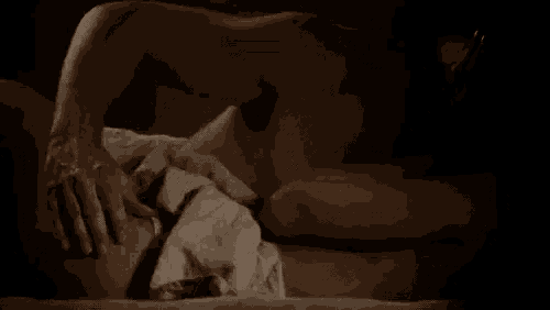a man and a woman are laying on a bed and the woman is touching the man 's butt .