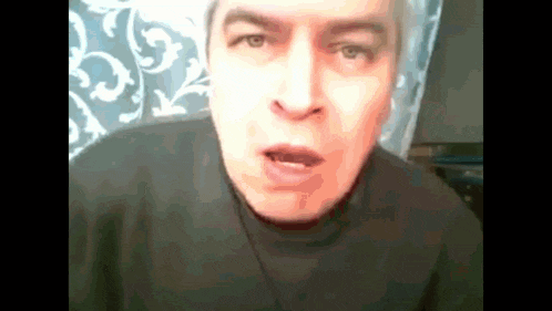 a man in a black sweater is making a funny face with his mouth open