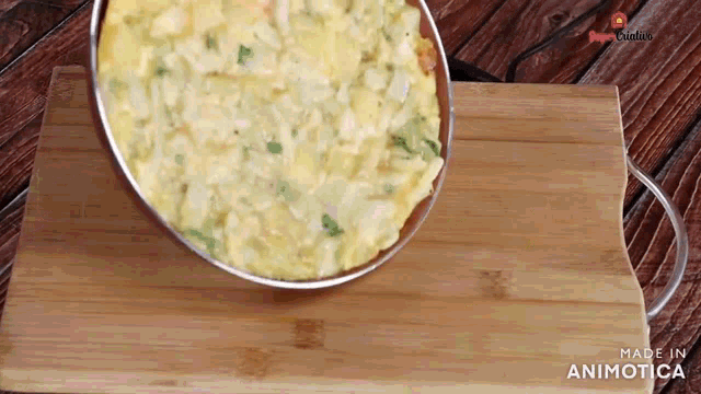 an omelet is being poured into a pan on a wooden cutting board made in animatica