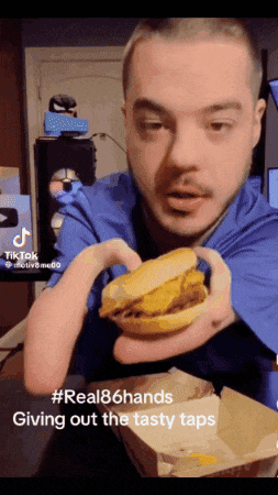 a man is holding a hamburger in his hands with a caption that says " real86hands giving out the tasty taps "