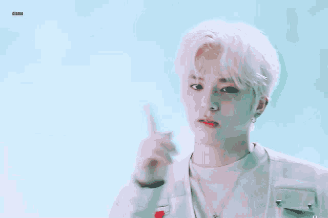 a young man with white hair is wearing a white vest and a white shirt .