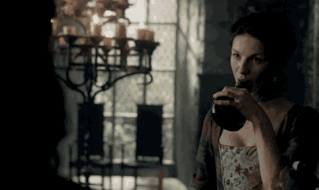 a woman in a corset drinks from a glass