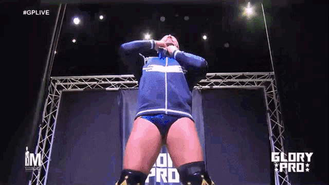a wrestler is standing in front of a screen that says glory pro