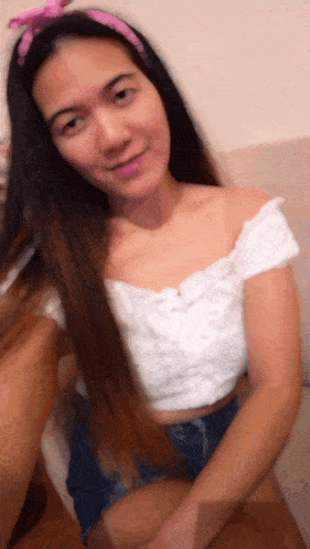 a woman wearing a white off the shoulder top and shorts