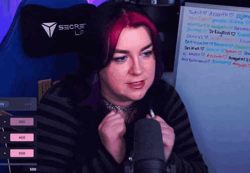 a woman with red hair is sitting in front of a white board that says seore la