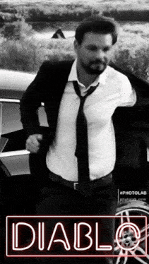 a man in a suit and tie is standing in front of a car with the word diablo on the bottom