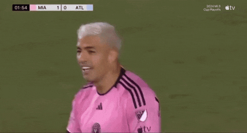 a soccer player is wearing a pink adidas jersey and smiling .