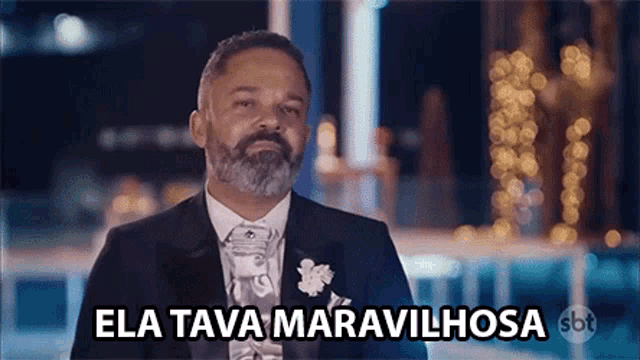 a man with a beard in a tuxedo says ela tava maravilhosa
