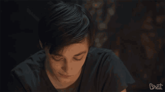 a close up of a boy 's face with the word brat in the corner