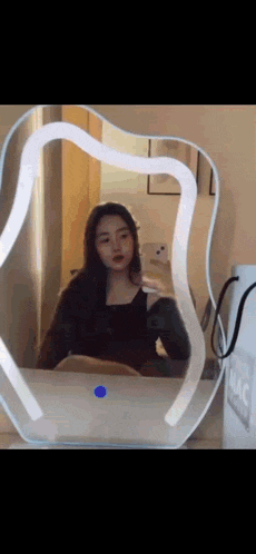 a woman is taking a selfie in front of a mirror that says mac on it