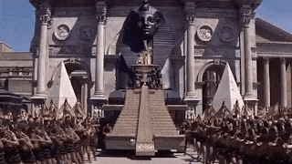 a large group of people are standing in front of a building with a sphinx in the background