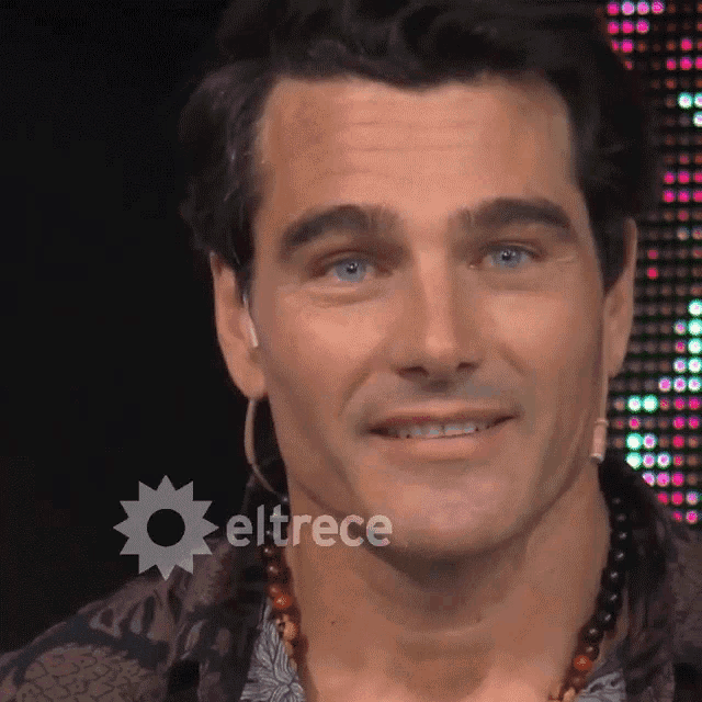 a close up of a man 's face with eltrece on the bottom right