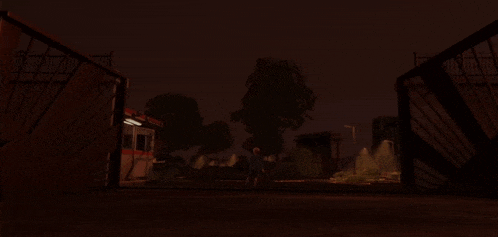a dark night scene with a fence and a building that says ' ambulance ' on it